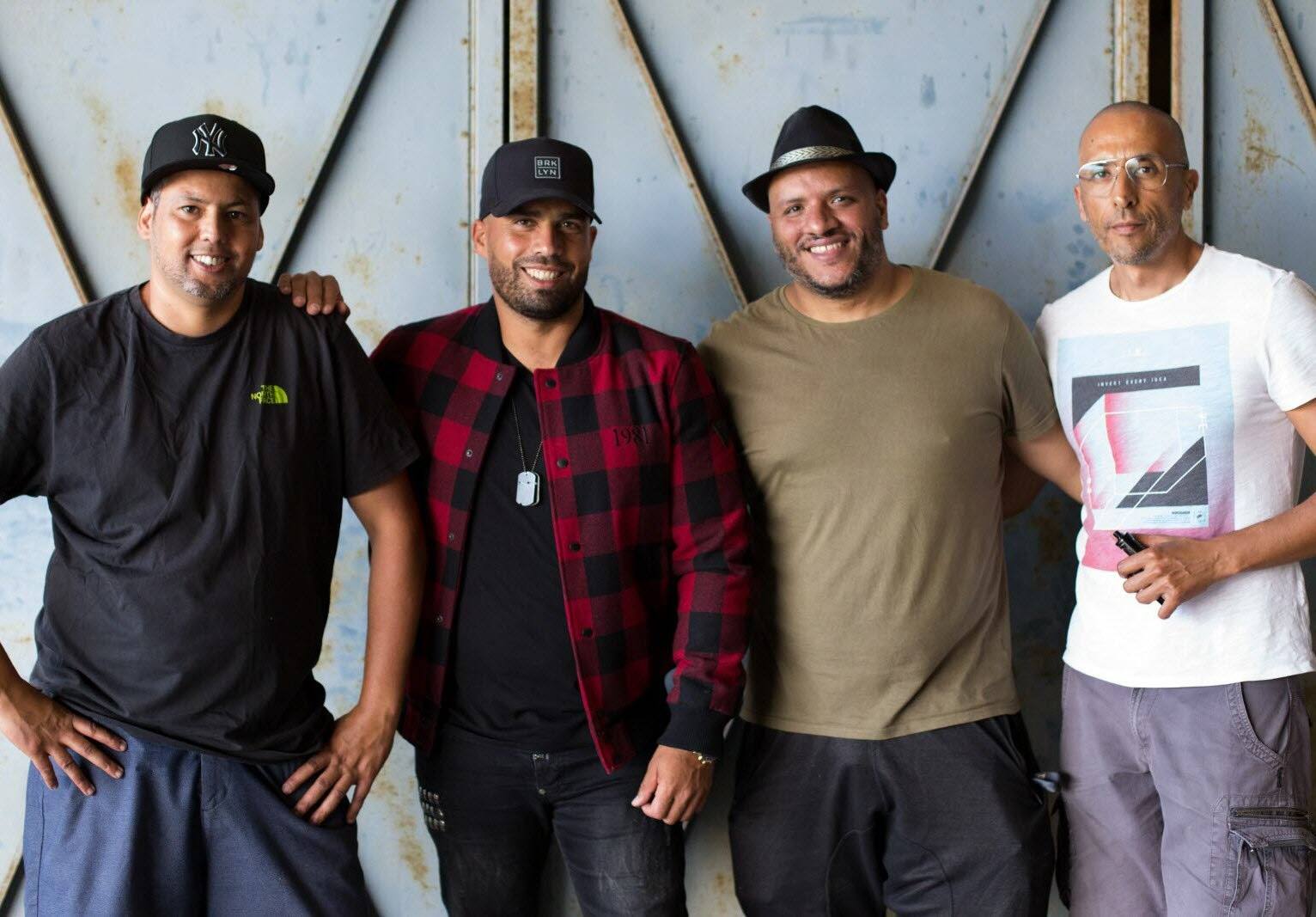 Four members of the Andale crew posing in front of hangar doors