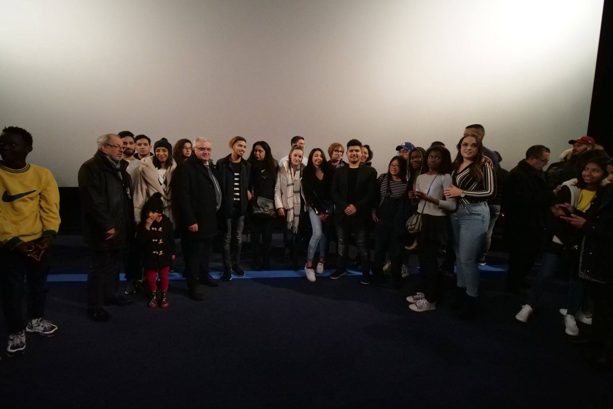 Participants and audience gathered in front of the screen after the screening